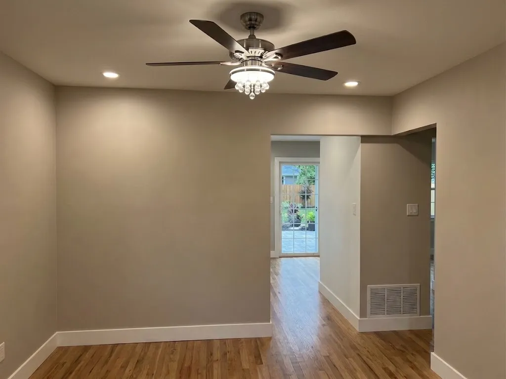 Finished room with greige walls, white baseboards, recessed lights, a ceiling fan and a doorway to the hall