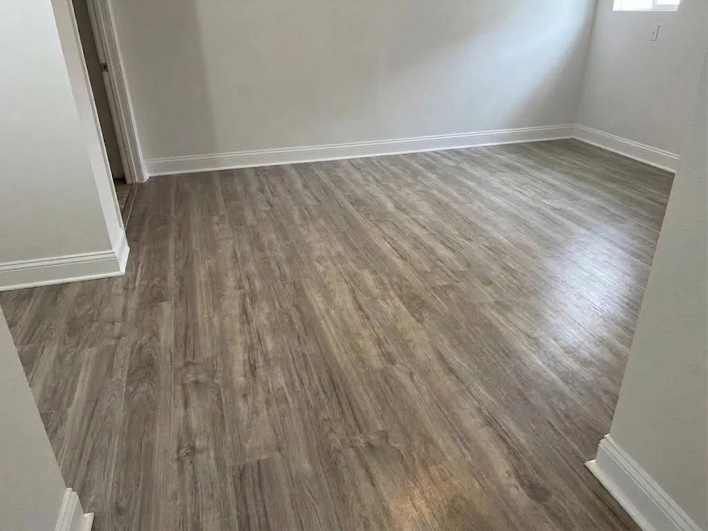 Finished room with gray wood-look plank flooring and white baseboards